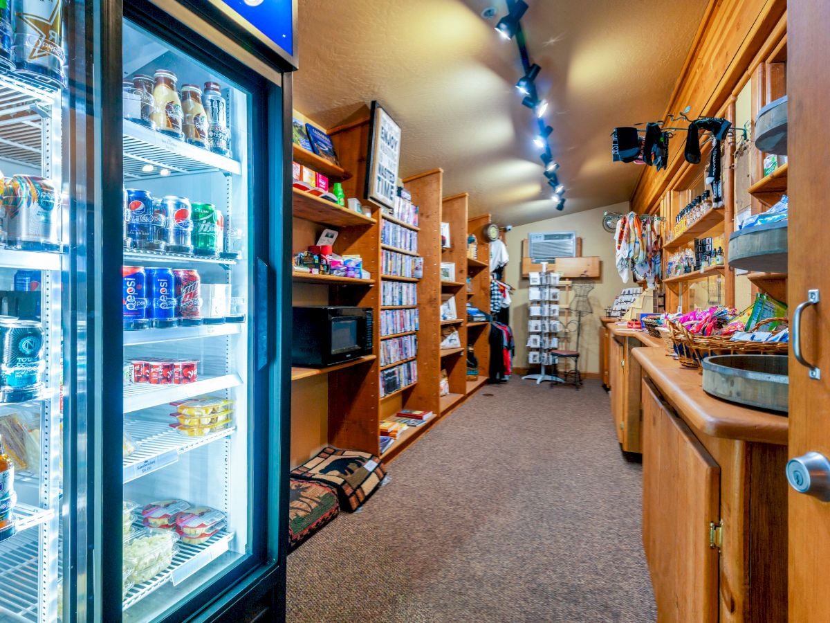 The image shows a small store with stocked shelves and a refrigerated section containing beverages. Various items are displayed throughout the store.