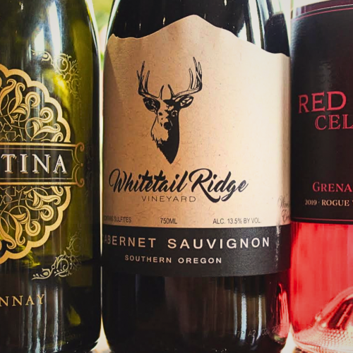 Three wine bottles labeled Coventina Chardonnay, Whitetail Ridge Cabernet Sauvignon, and Red Hills Cellars Grenache Rosé are side by side.