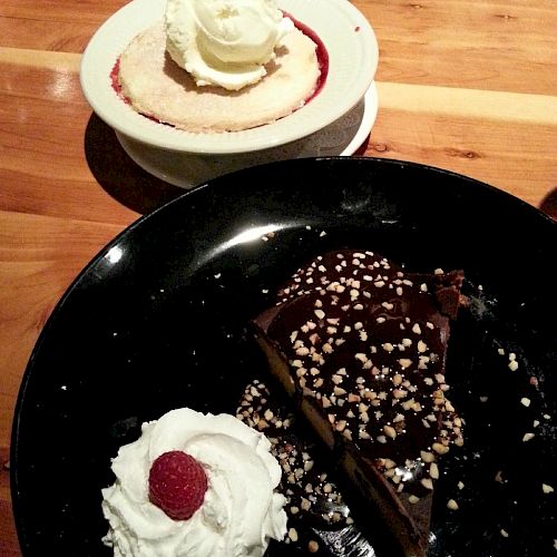 The image shows two desserts: a pie with whipped cream and a raspberry, and a chocolate cake with whipped cream and a raspberry on the side.