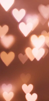 The image contains a bokeh effect background with soft, out-of-focus heart shapes in various sizes and warm colors.